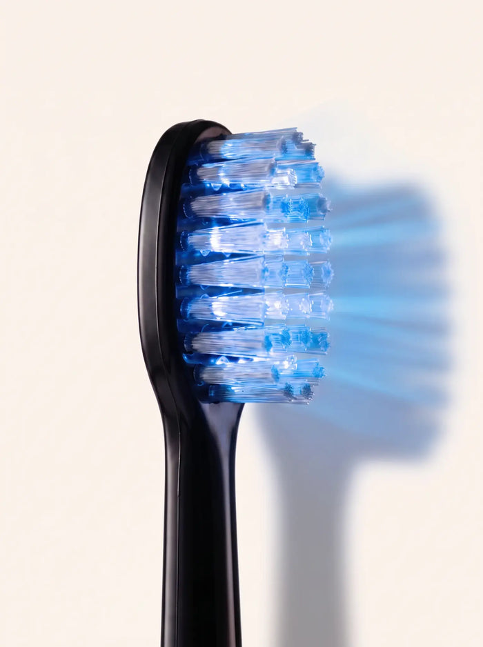 Macro side view of the Helios brush head illuminated with red light