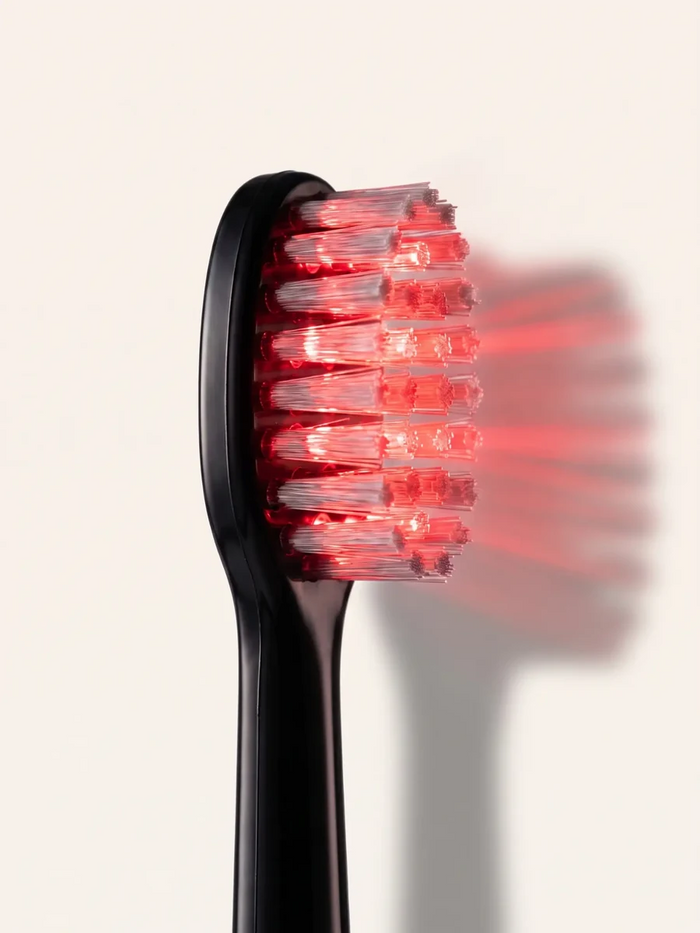Macro side view of the Helios brush head illuminated with red light