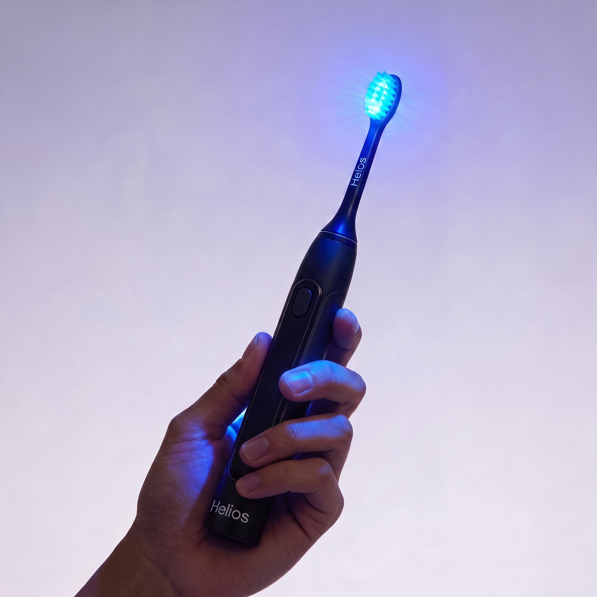 Helios toothbrush held securely in one hand with the brush head illuminated