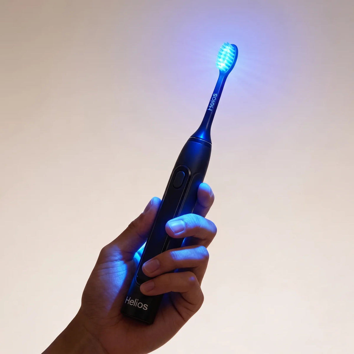 Helios toothbrush held securely in one hand with the brush head illuminated